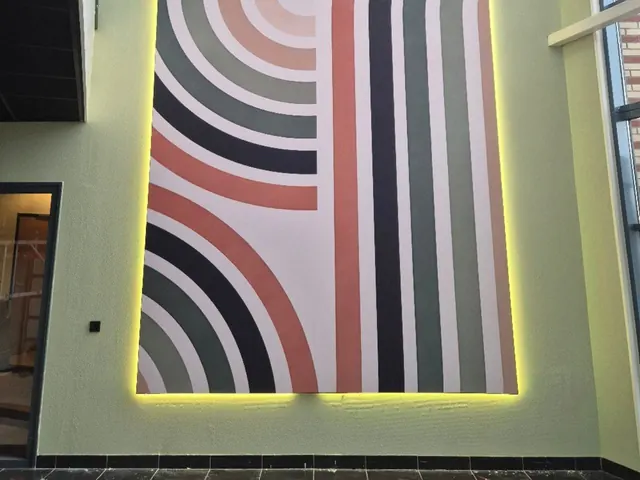 Wand met een print van gekleurde bogen en ledverlichting