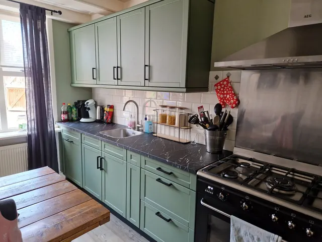 Keuken met mintgroene kastdeurtjes en een gespikkeld blad
