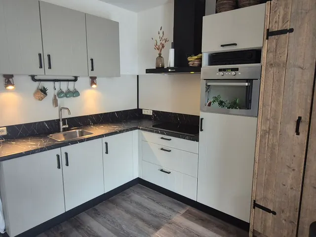 Witte keuken met een zwart blad