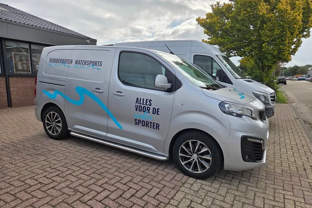 Twee bedrijfsbussen met belettering