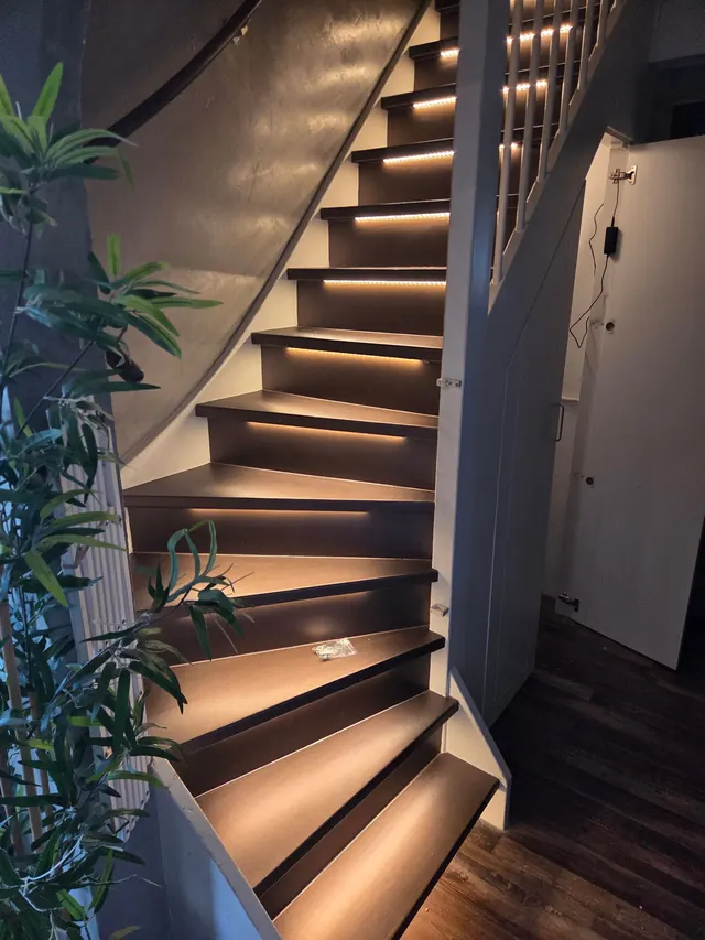 Donkere trap met houtlook en ledverlichting onder de treden